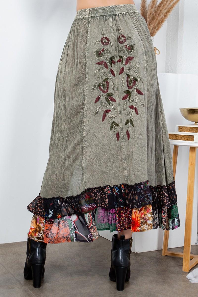 Detail of the multi-patterned ruffle hem on this artisan-crafted gray midi skirt with earthy tones.
