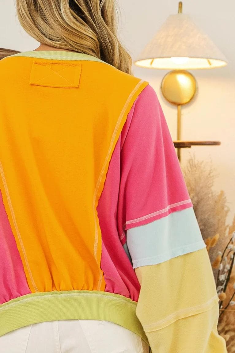 Flat lay of the neon patchwork cotton-blend sweatshirt displaying the full colorblock arrangement and boxy fit.