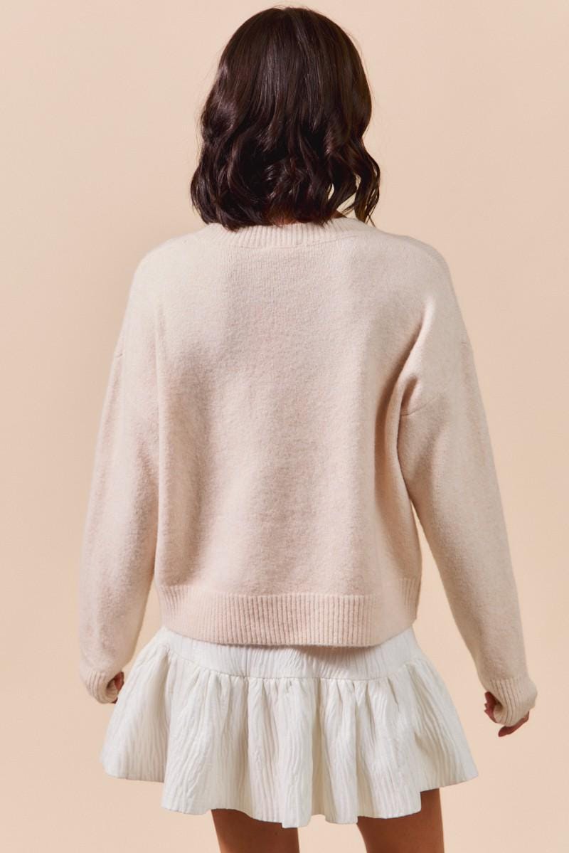 Texture detail of the polyester and nylon knit blend on the pink ribbon embroidery pullover