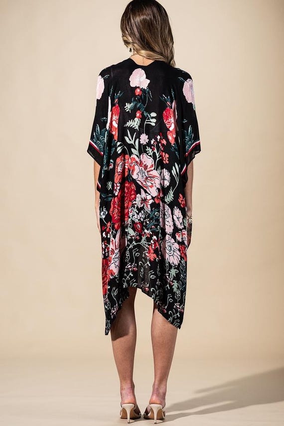 Overhead view of a flowing black floral print wrap cardigan, 38-inch length, showcasing oversized botanical pattern.