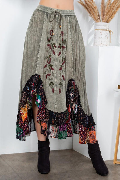 Close-up of intricate floral embroidery on textured gravel gray fabric for a Whimsigoth aesthetic.