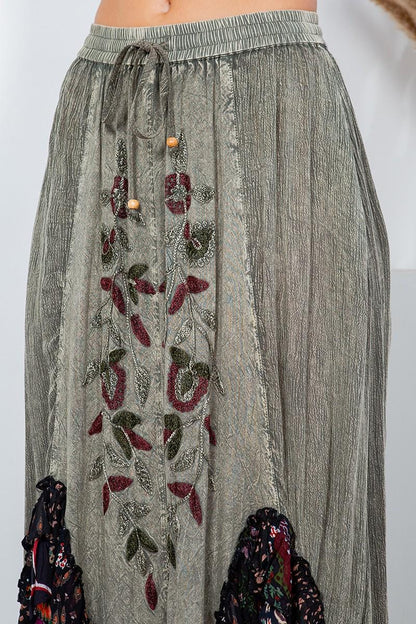 Side profile of the bohemian asymmetrical skirt highlighting the deep pockets and functional drawstring waist.