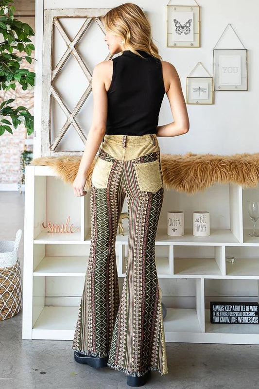 Back view of high-waisted Aztec print bell bottoms with tan corduroy yoke, geometric patterns, and raw frayed hem.