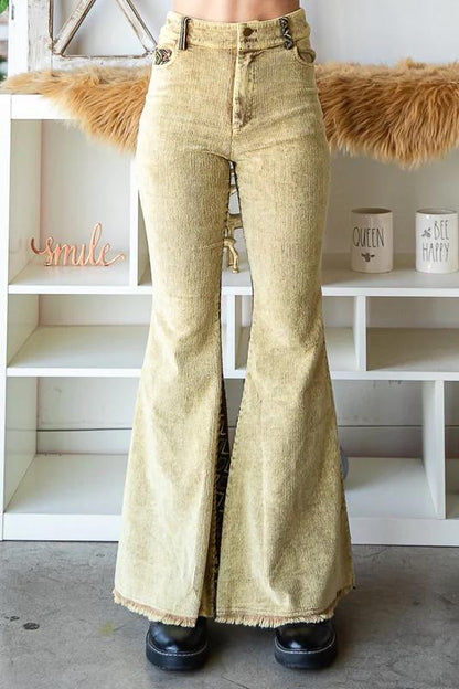 Full-length view of a model wearing tan corduroy Aztec flare pants for an eclectic Western look.