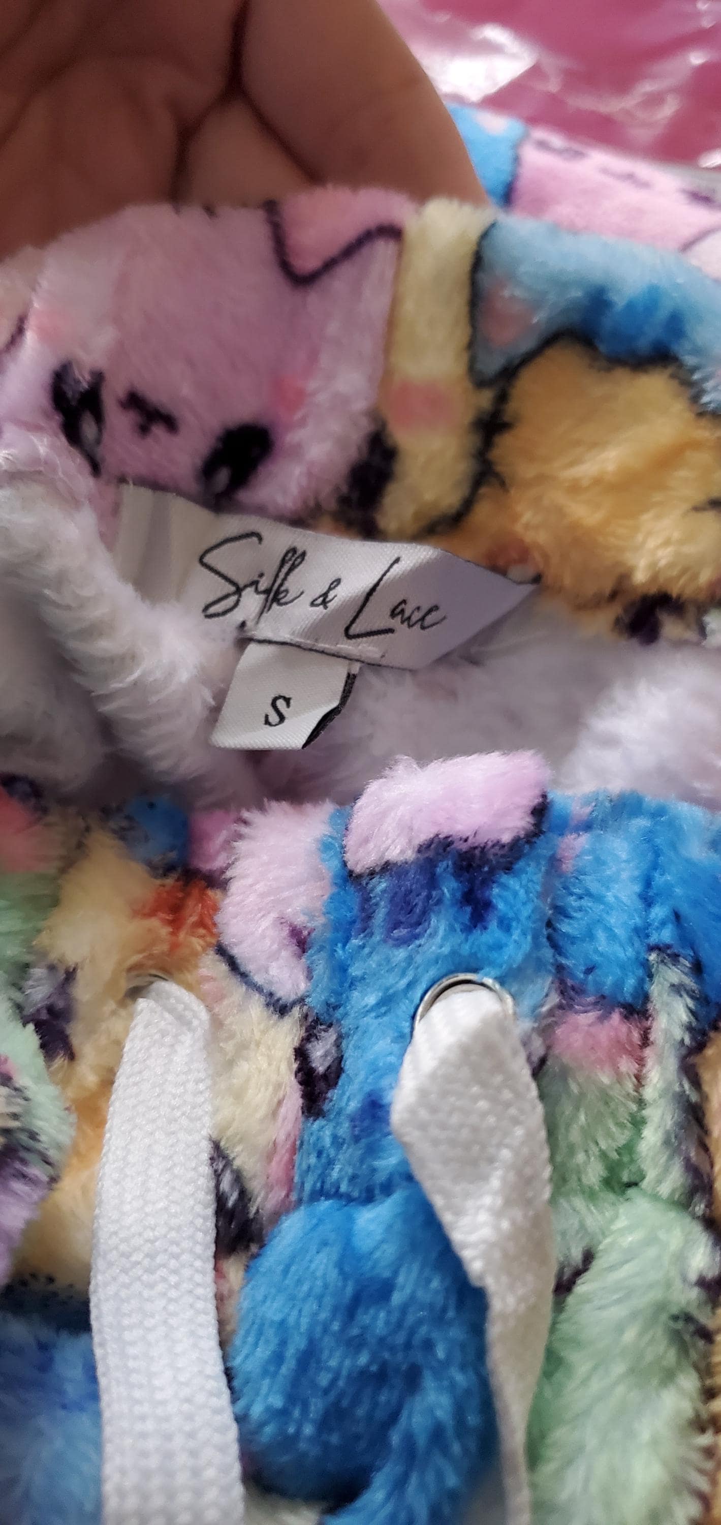 Soft 100% polyester plush fleece fabric detail of the pink and blue cat face print pants.
