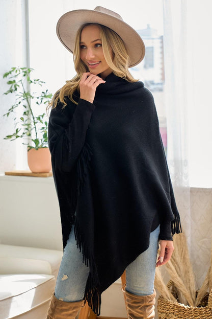 Close-up of the 100% acrylic knit material and artisanal fringe detail on a black western-style wrap