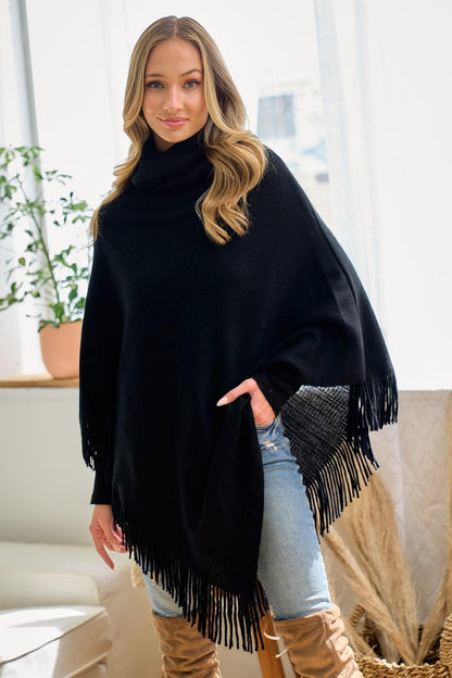 Model wearing a black western-inspired poncho styled with jeans for a coastal cowgirl aesthetic