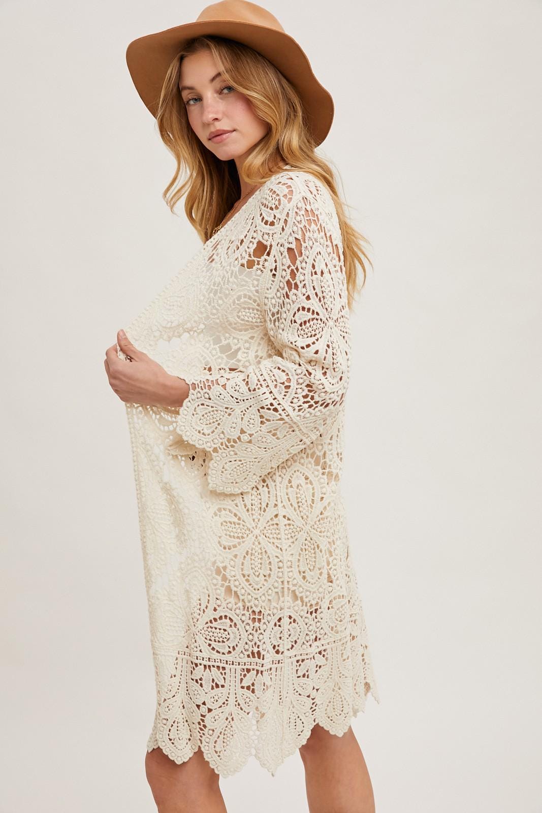 Side angle of a whimsigoth style crochet lace cardigan featuring long sleeves and breathable knit