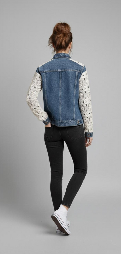 Back view of a mid-wash blue denim jacket featuring cream floral lace crochet sleeves and a vintage boho-chic aesthetic.