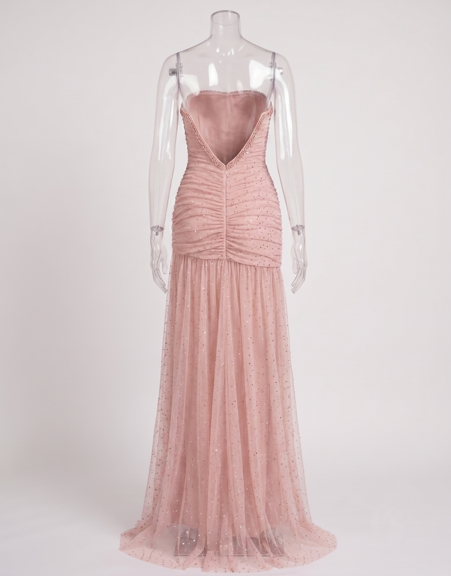 Side angle of the blush pink rhinestone dress showcasing the flattering ruched fit and dramatic leg slit.