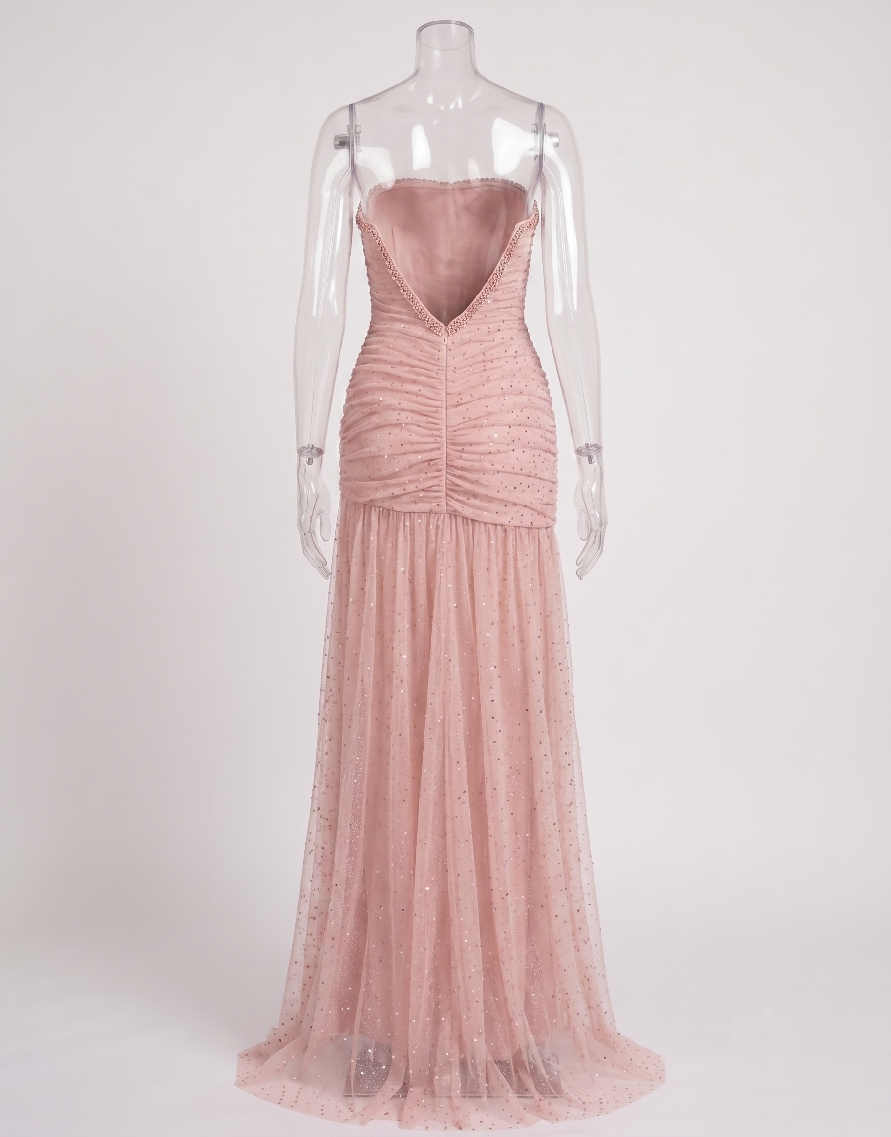 Side angle of the blush pink rhinestone dress showcasing the flattering ruched fit and dramatic leg slit.