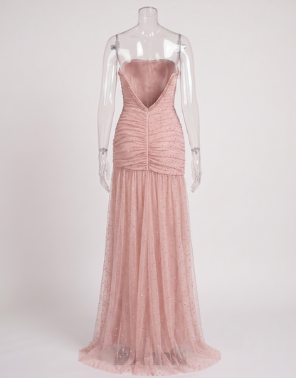 Side angle of the blush pink rhinestone dress showcasing the flattering ruched fit and dramatic leg slit.