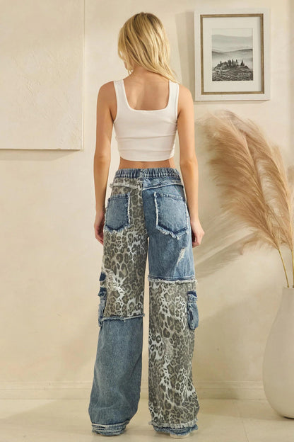 Side profile of relaxed fit blue denim cargo pants with distressed leopard print accents