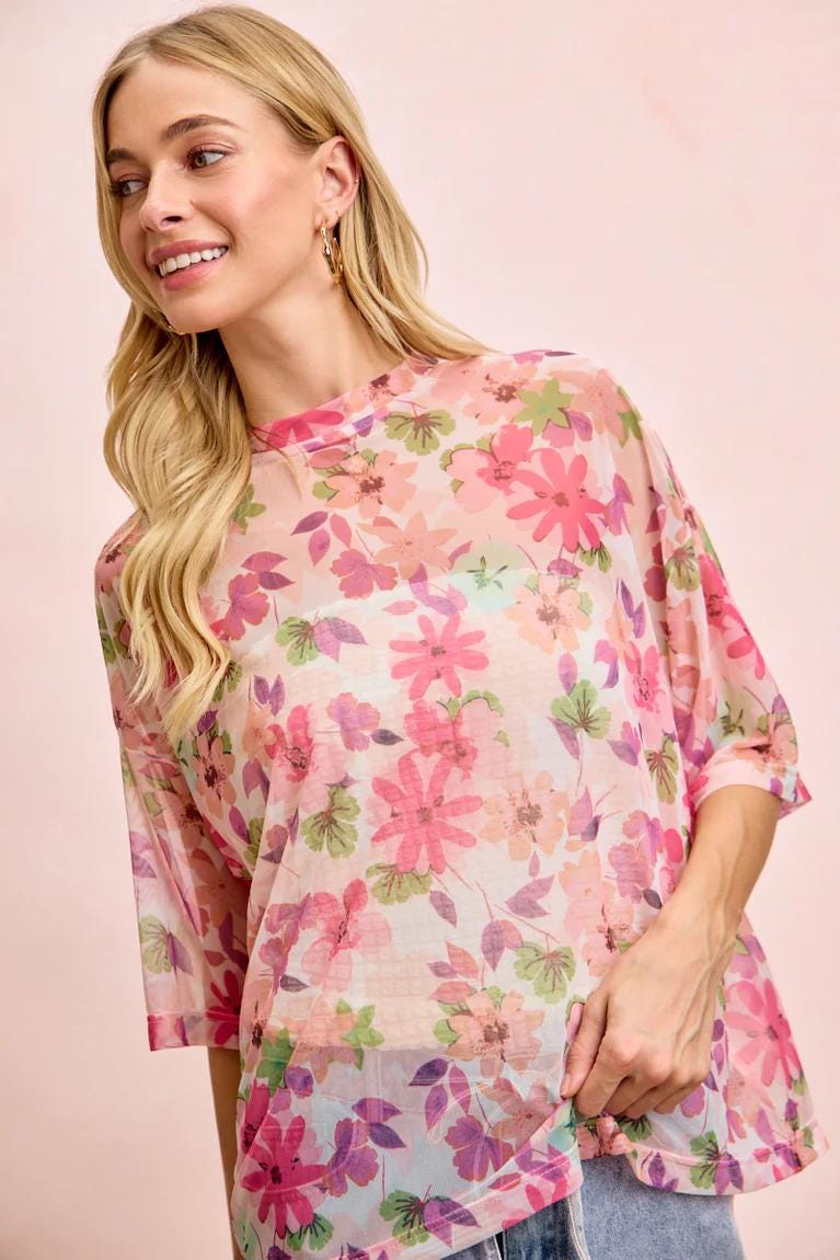 Close-up detail of the semi-transparent mesh fabric with delicate rose-colored floral patterns
