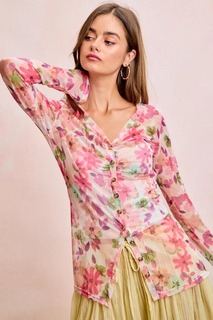 Architectural pointed hem design on the bottom of a cream-colored floral v-neck fairycore blouse