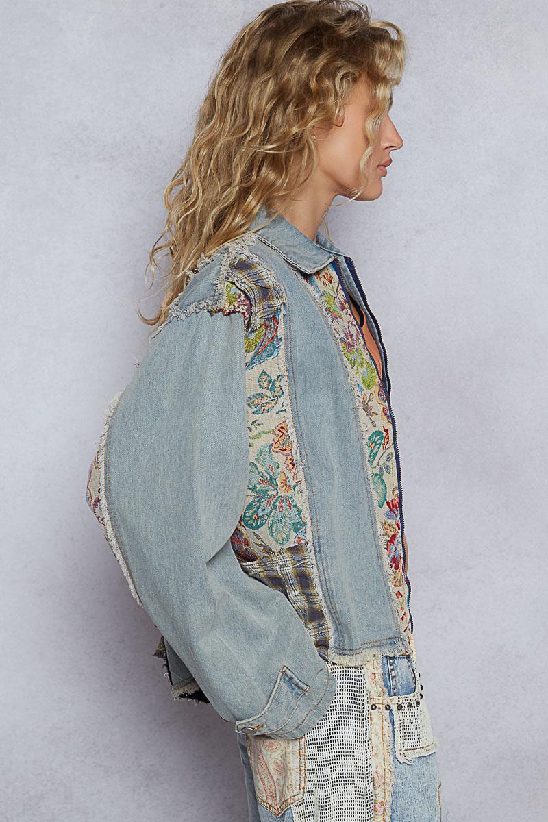 Detail of the adjustable drawstring hem on a light blue denim jacket with frayed edge accents