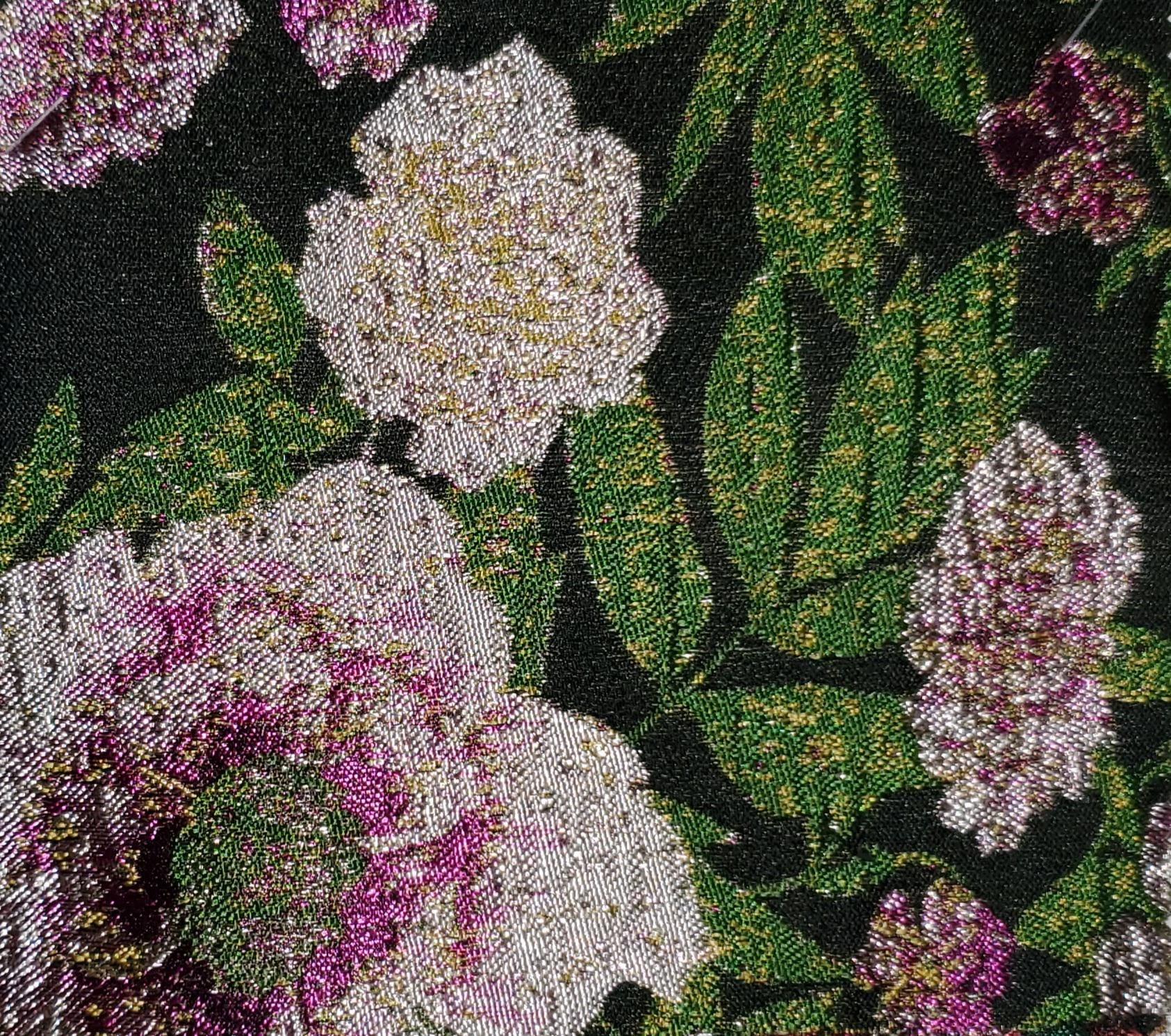 Close-up of vintage-style metallic jacquard fabric on a floral tapestry hoodie with intricate silver-studded detail