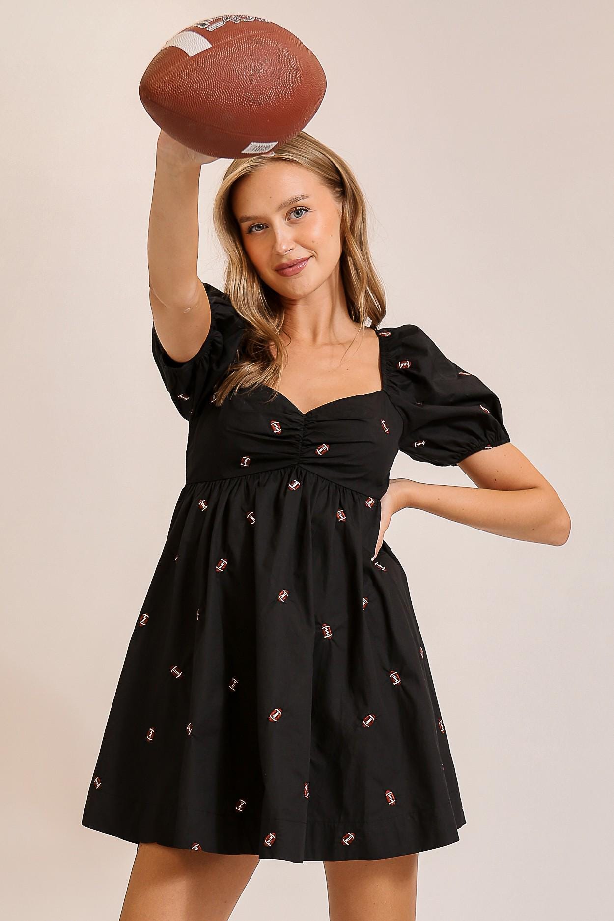 Lifestyle shot of the preppy athleisure football dress, a perfect sporty chic outfit for stadium events