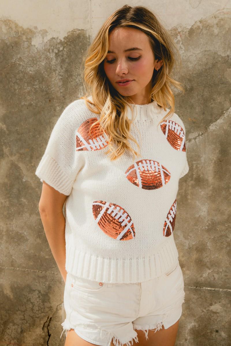 Full length view of the white knit football sweater displaying the symmetrical sequin pattern