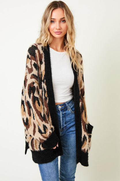 Lifestyle shot of a woman wearing a leopard print oversized sweater styled for a trendy indie sleaze look.
