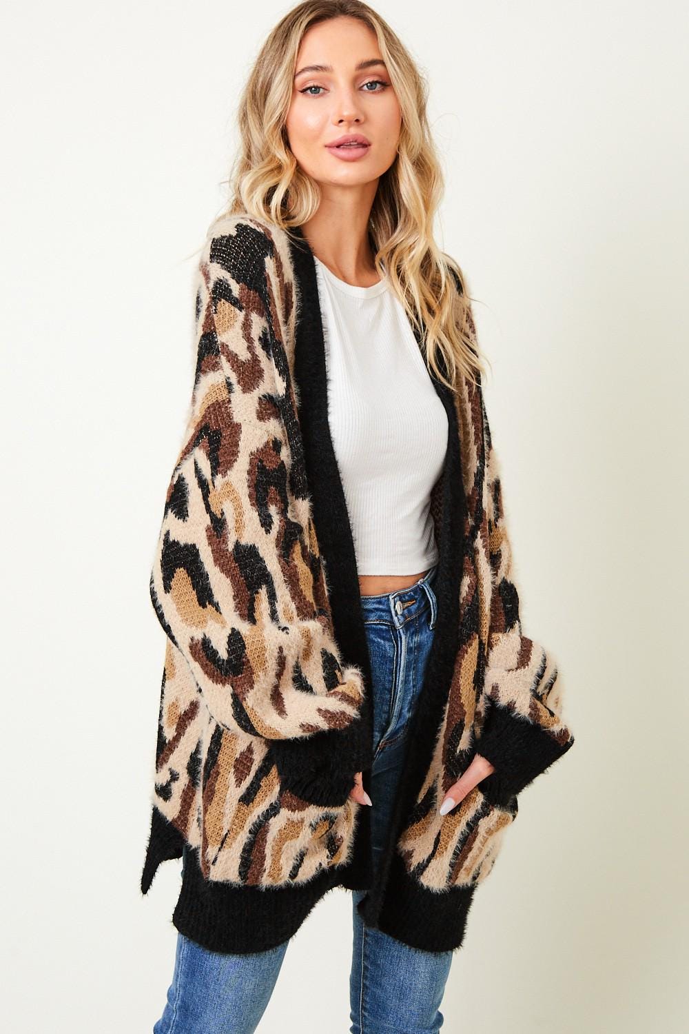 Side profile of a plush leopard cardigan highlighting the deep front pockets and soft mohair-like texture.