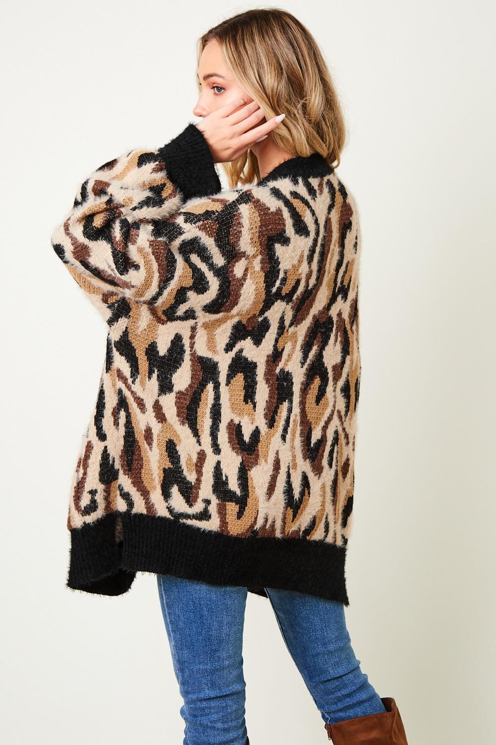 Detailed view of the cuff and sleeve on a luxurious leopard print eyelash knit cardigan for winter warmth.