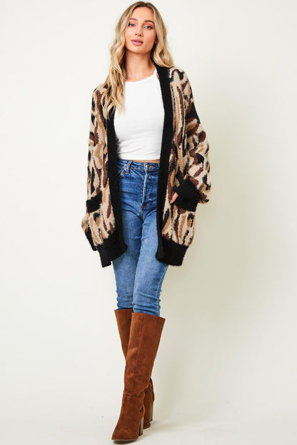 Full-body street style photo featuring a maximalist leopard print oversized cardigan with a bold pattern.