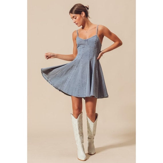 Back profile of the blue chambray fit and flare dress showing the zipper closure and paneled skirt design