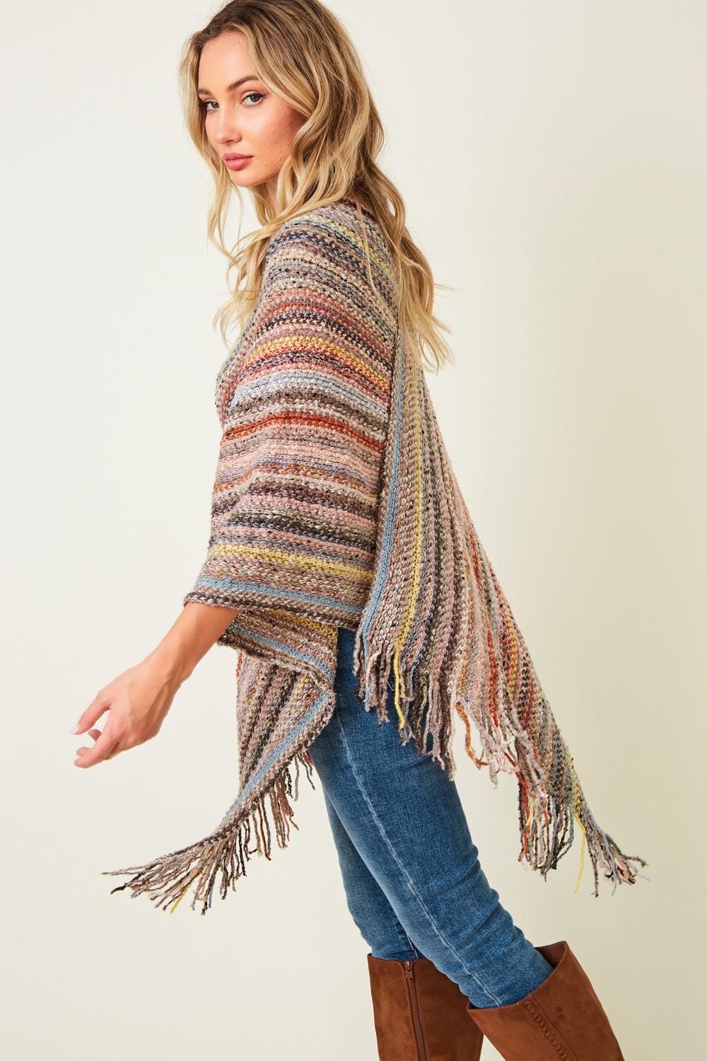 Side angle of the Southwestern style poncho highlighting the asymmetrical silhouette and hand-finished fringe.