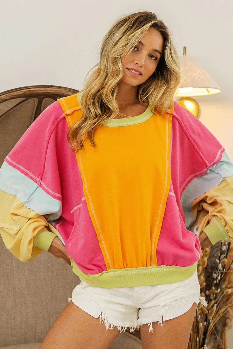 Model wearing the dopamine dressing style neon sweatshirt styled with streetwear for a maximalist kidcore look.
