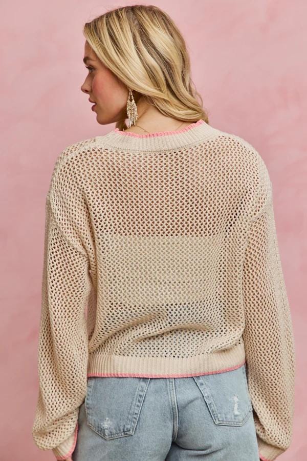 Lifestyle image of the tropical core knit sweater paired with summer accessories for a vacation outfit.