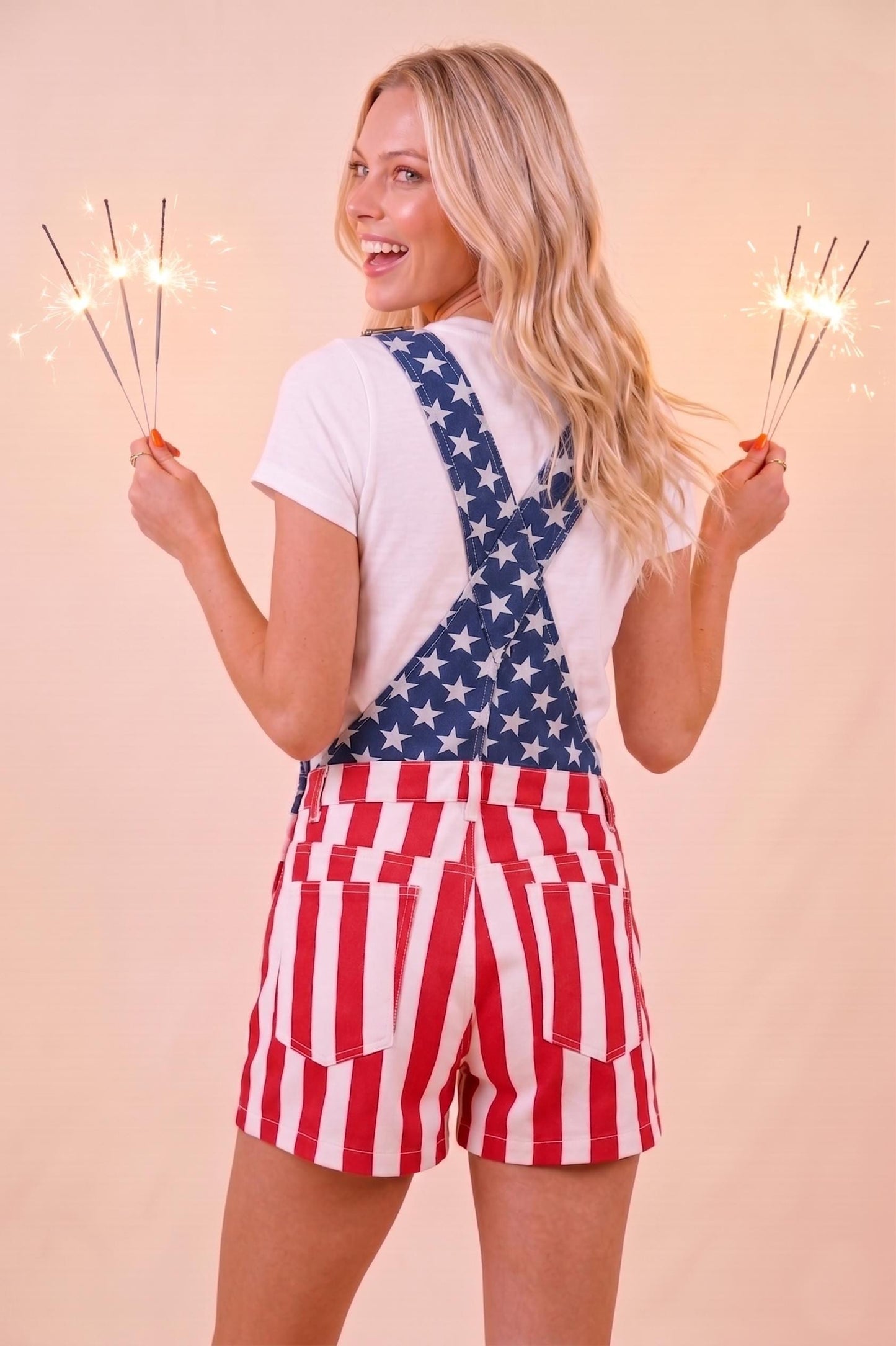 Rear view of retro-vintage Americana short overalls featuring vertical red and white stripes and relaxed fit