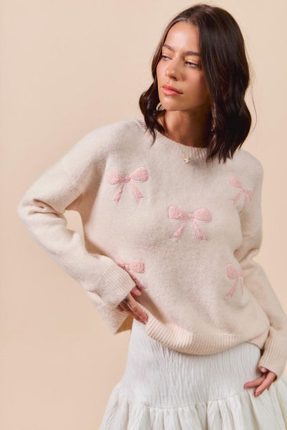 Close-up of pink bow embroidery on the soft girl knit pullover highlighting the balletcore style