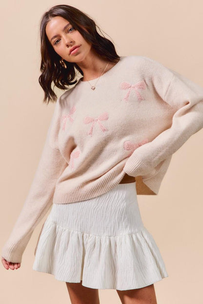 Side view of the relaxed fit cream pullover with pink ribbons perfect for a minimalist pastel outfit