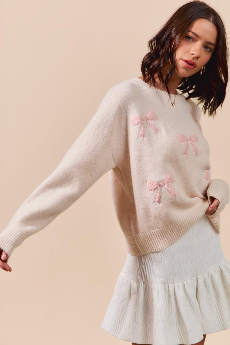 Full-length styled look with the pink bow coquette sweater paired with feminine accessories