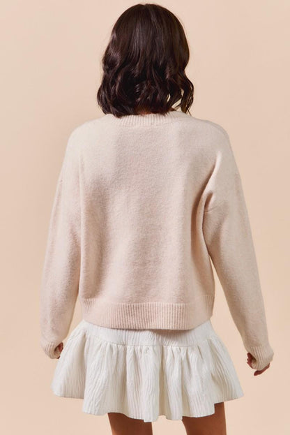 Texture detail of the polyester and nylon knit blend on the pink ribbon embroidery pullover