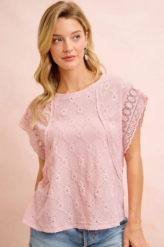 Lifestyle shot of a boho lace top styled for summer with light wash denim jeans and gold jewelry.