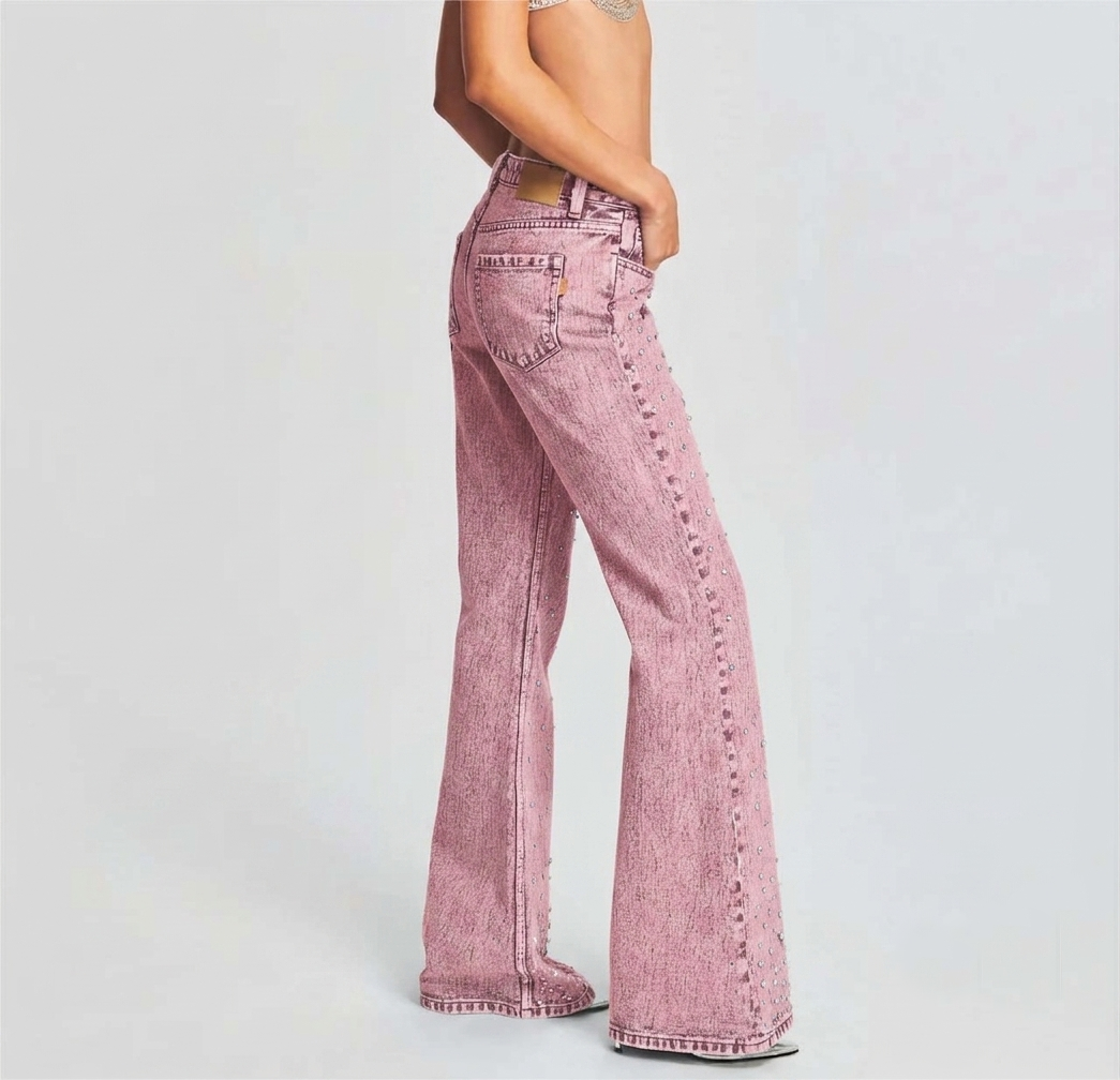 Close-up of pink acid-wash denim texture featuring scattered rhinestone embellishments for a festival style look