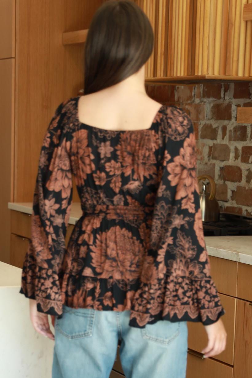Side angle of vintage-inspired bell sleeves on a black and rust botanical print whimsigoth top