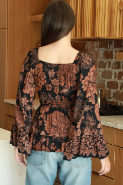 Side angle of vintage-inspired bell sleeves on a black and rust botanical print whimsigoth top