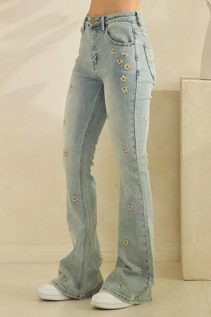 Full length shot of whimsigoth daisy embroidered flare jeans paired with a boho top