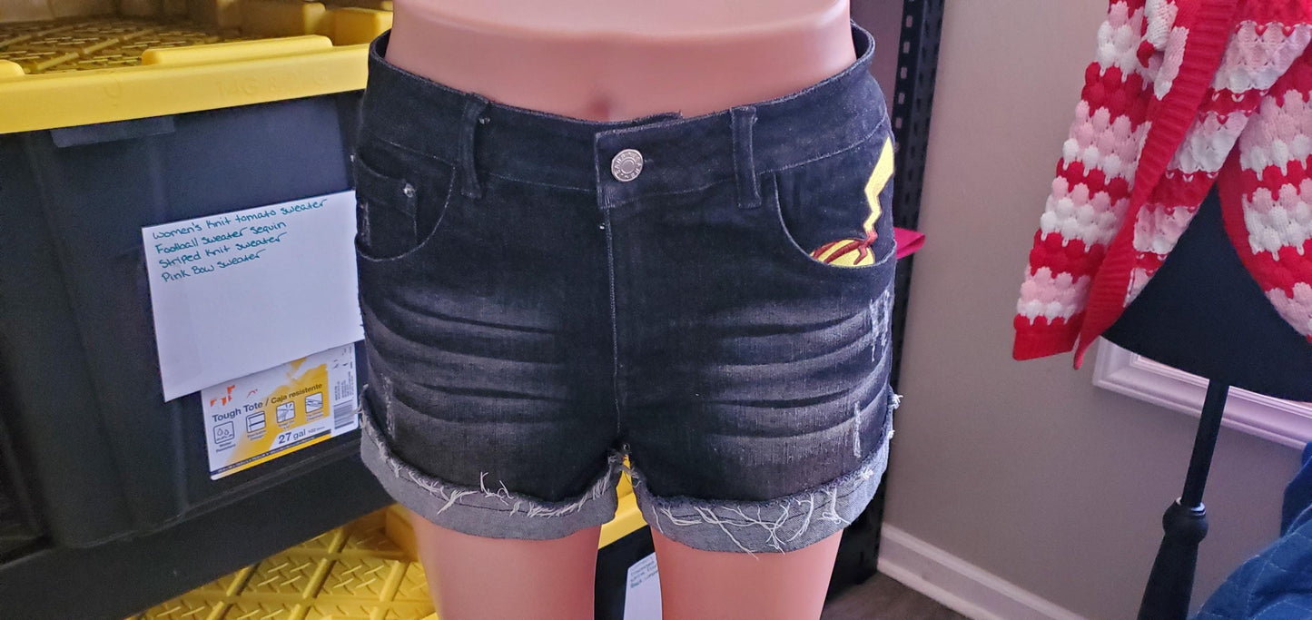 Rear view of black Y2K denim shorts with unique anime embroidery peeking from the pocket.