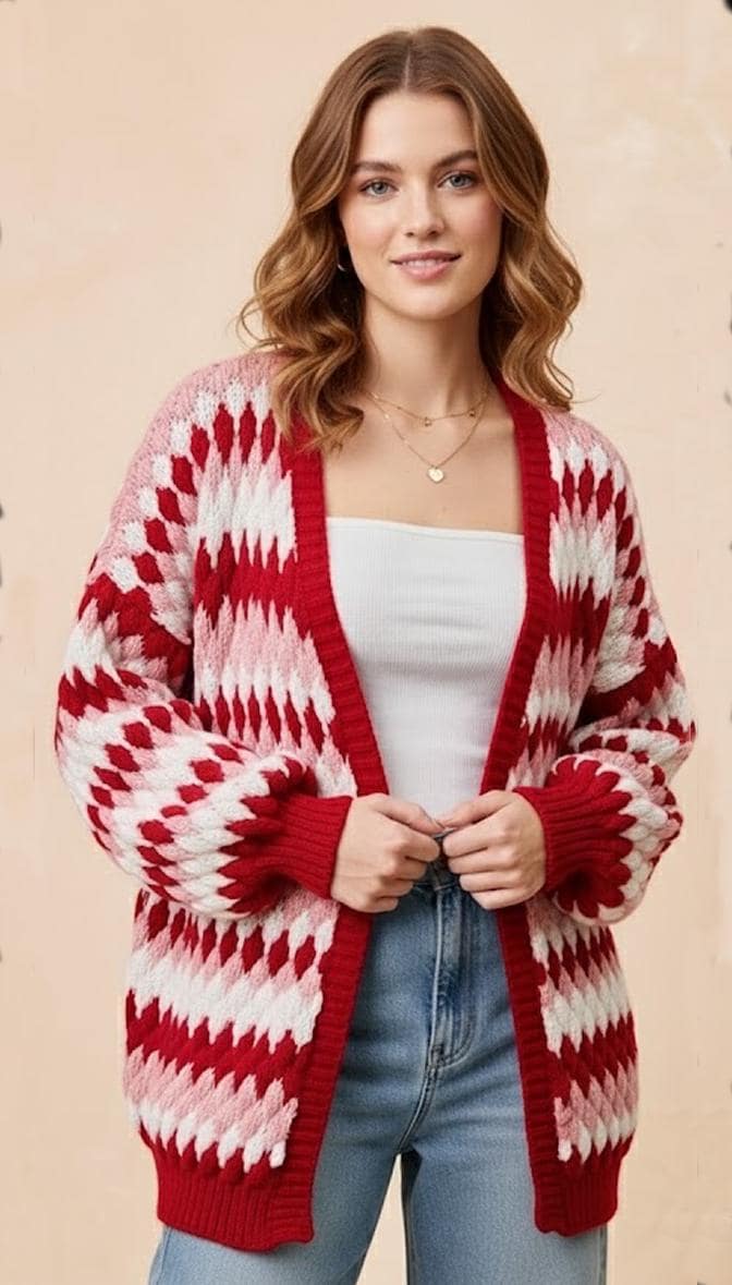 Front view of a pink and red diamond knit acrylic cardigan with an oversized silhouette and balloon sleeves