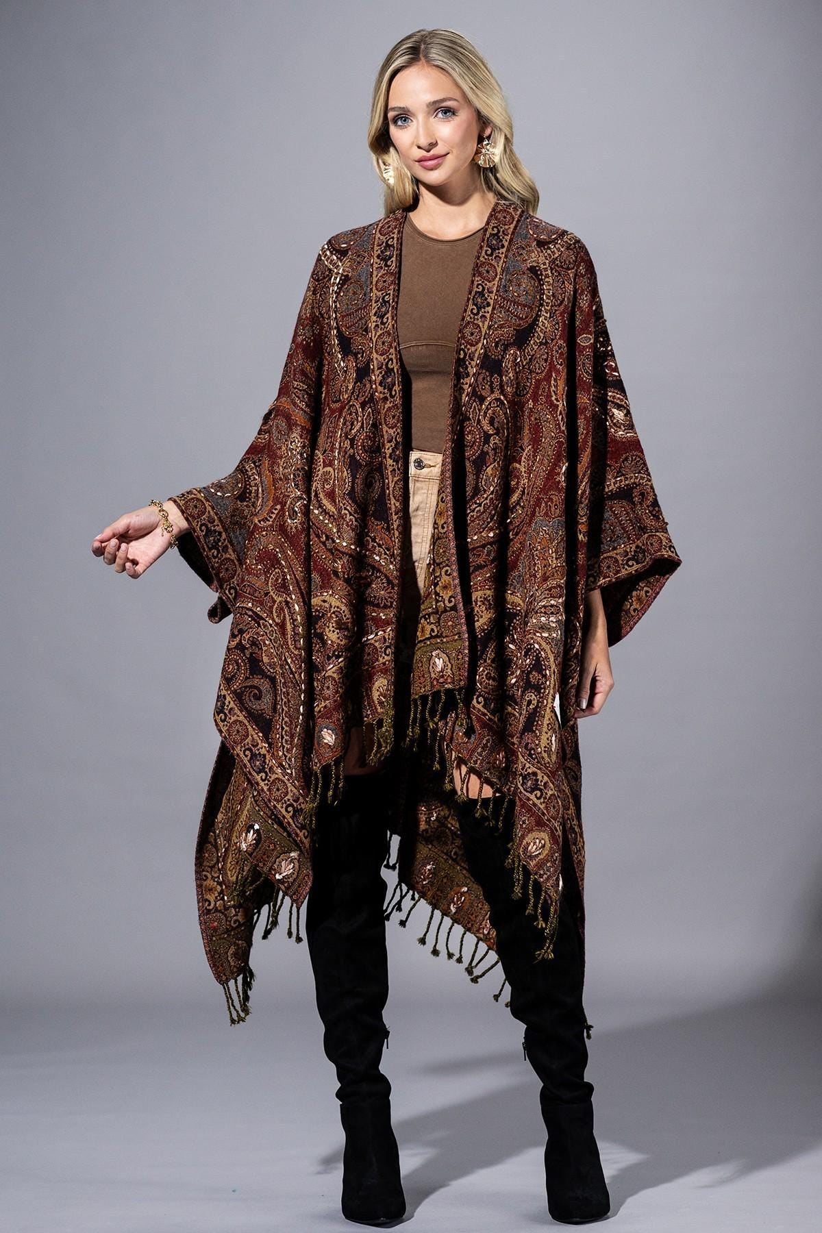Front view of a burgundy and bronze paisley wool ruana with bohemian fringe details