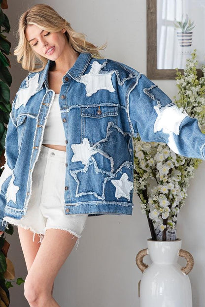 Close-up of hand-finished white star appliqués and raw-edge fringe on blue distressed cotton denim.