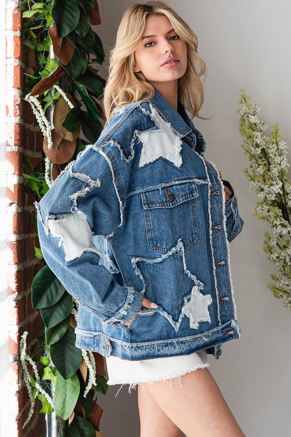 Side profile of a medium blue distressed denim jacket featuring a relaxed boyfriend fit and star patchwork.