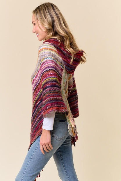 Side profile of the Southwestern style poncho featuring a functional hood and fringed hem