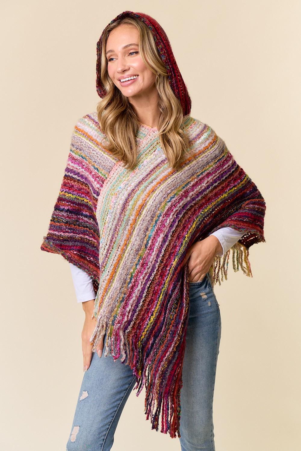 Close-up of the decorative fringe on the burgundy and multi-color woven poncho