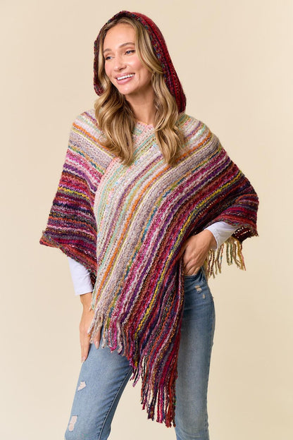 Close-up of the decorative fringe on the burgundy and multi-color woven poncho