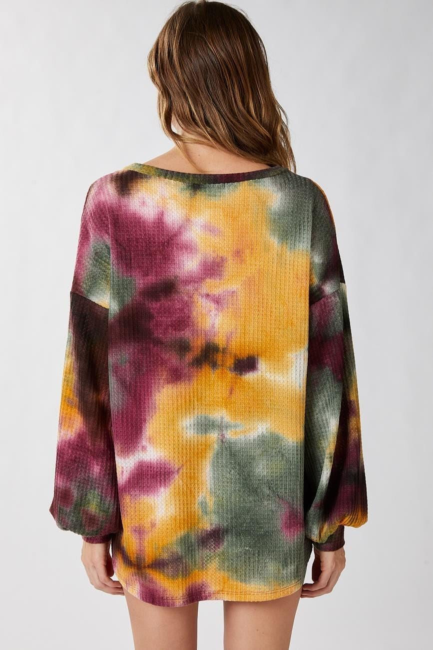 Close-up detail of the textured ribbed knit fabric on a vibrant olive green and maroon tie dye sweater.